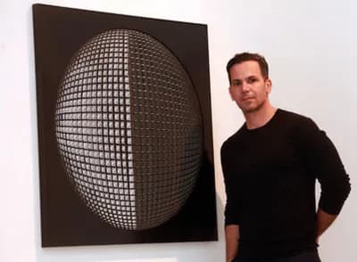 Ben Abounassif standing beside one of his relief panels