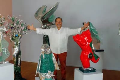 Apostol Nikolakopoulos photographed between two of his sculptures