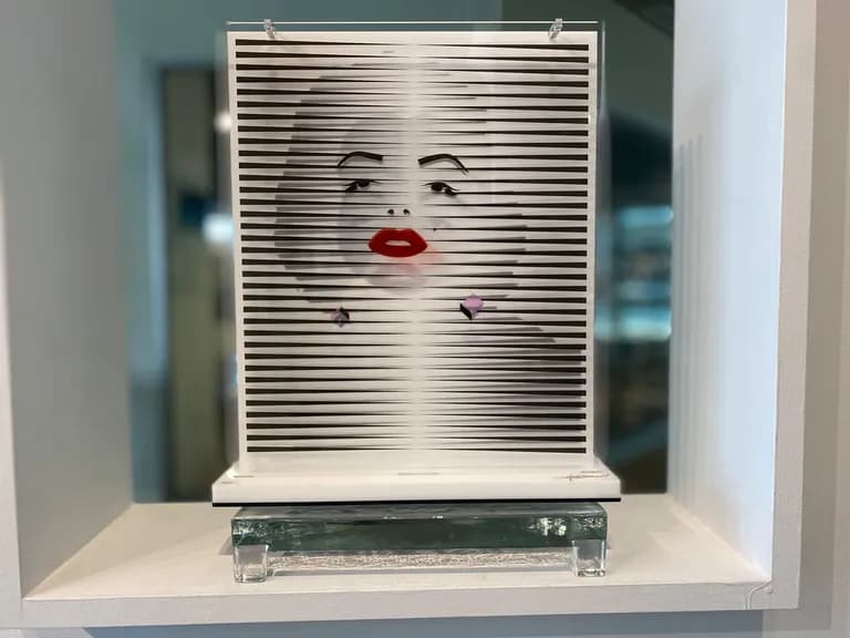 A woman's face with red lips by Hugo Diaz, printed across white louvres