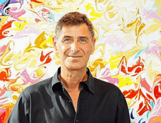 Eduardo Guelfenbein photographed in front of one of his paintings