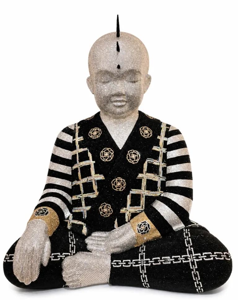 A seated Punkbuddha by Metis Atash in black and cream, encrusted with crystals