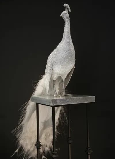 A crystal encrusted peacock by Clarita Brinkerhoff with its tail down