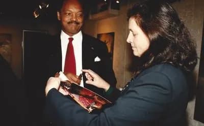 Lorna Marsh autographing a book for Reverend Jesse Jackson