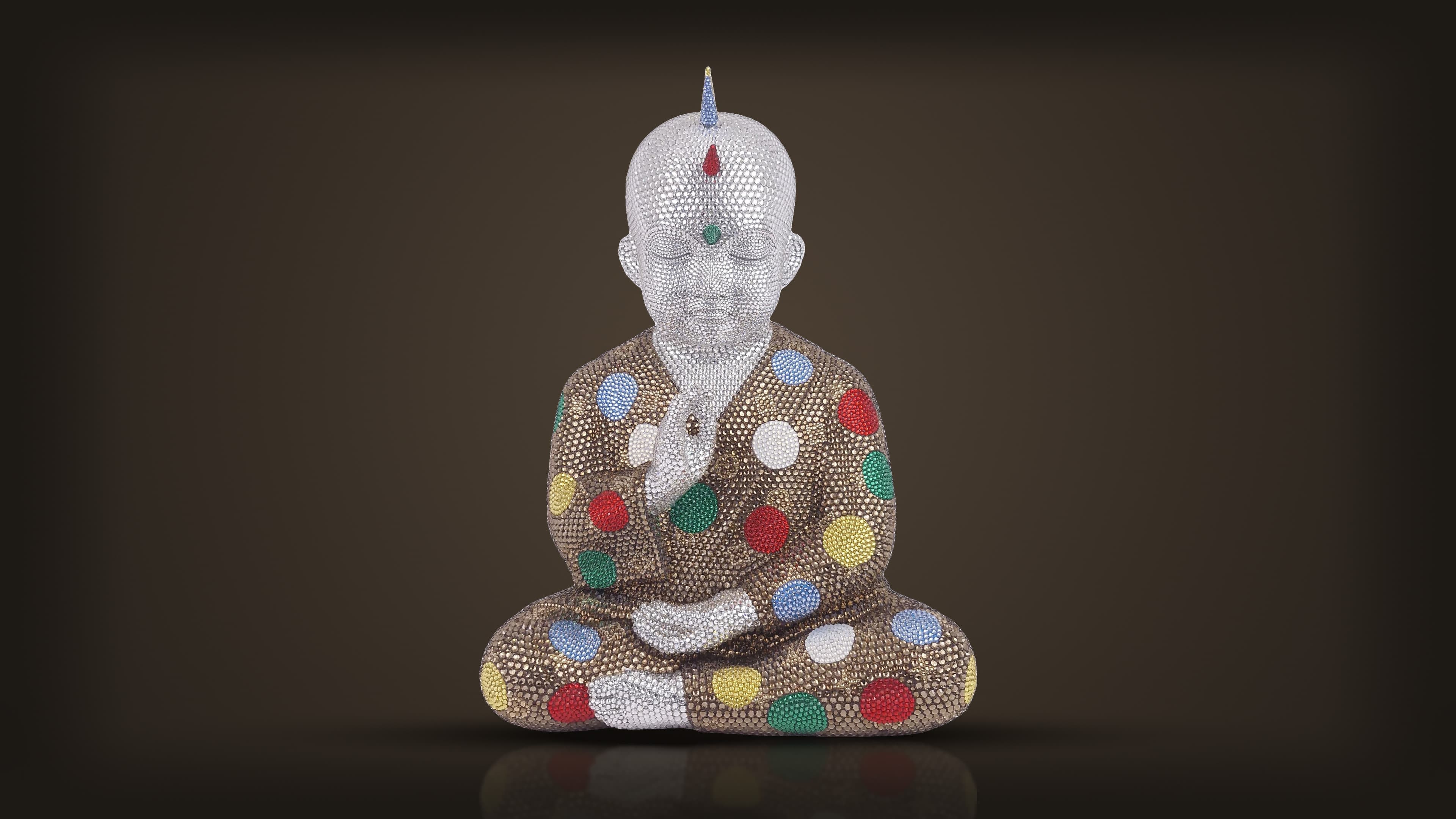 Metis Atash, Kusama Vuitton, from the front: a seated crystal Buddha in a bronze robe scattered with coloured dots, one hand raised, a spike rising from the crown